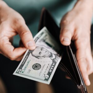 unrecognizable man holding wallet with money