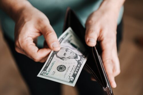 unrecognizable man holding wallet with money